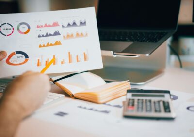 a person holding a piece of paper over a laptop